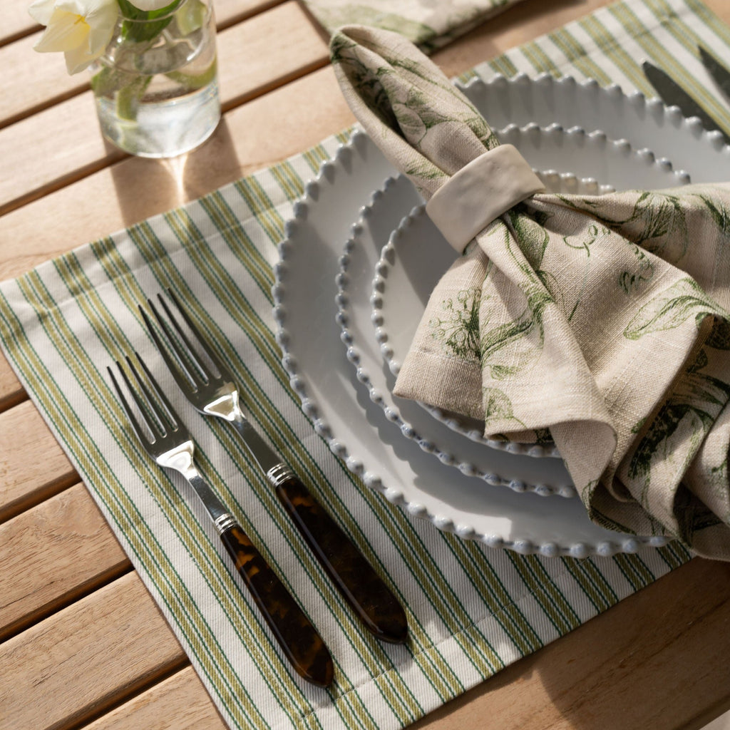 Anson Aloe Placemat Displayed with a Flora Basil Dinner Napkin on an Outdoor Table