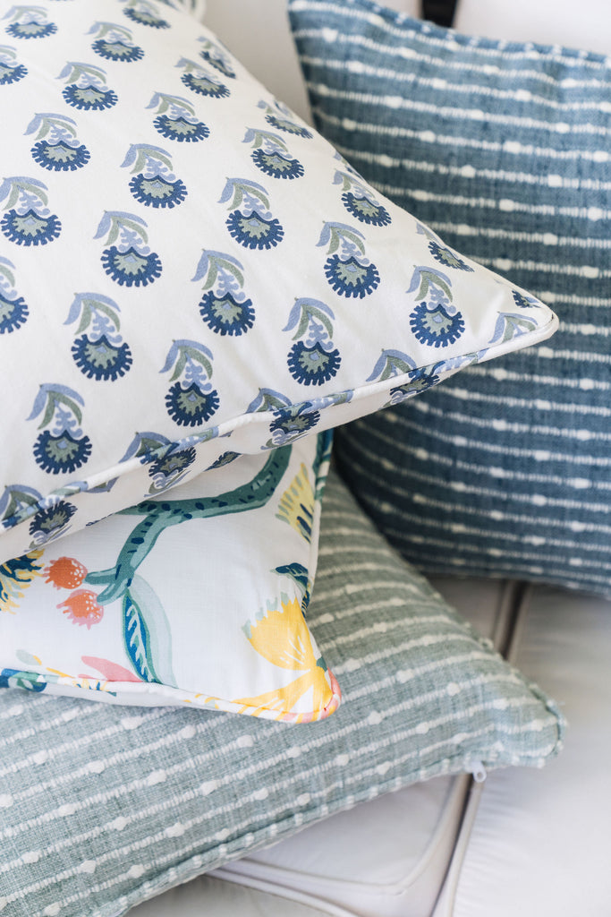 colorful printed pillows and embroidered pillows on an outdoor couch